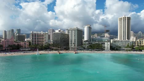 a drone pans from side to side at a tropical beach location revealing luxury water front hotels