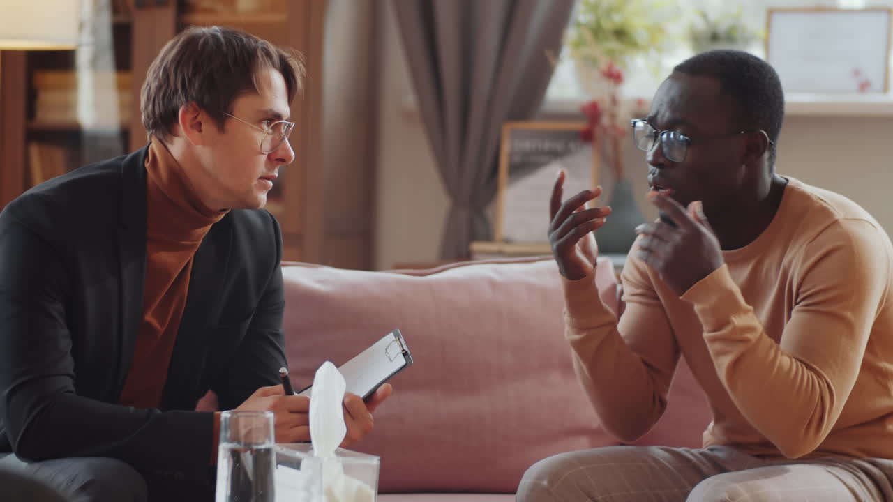 hombre negro molesto quejándose al psicólogo en una sesión de terapia