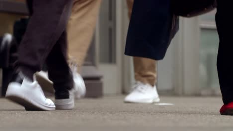 people walk on the street, close up to feet, shoes, boots, sneakers. day time, busy street. spring time.