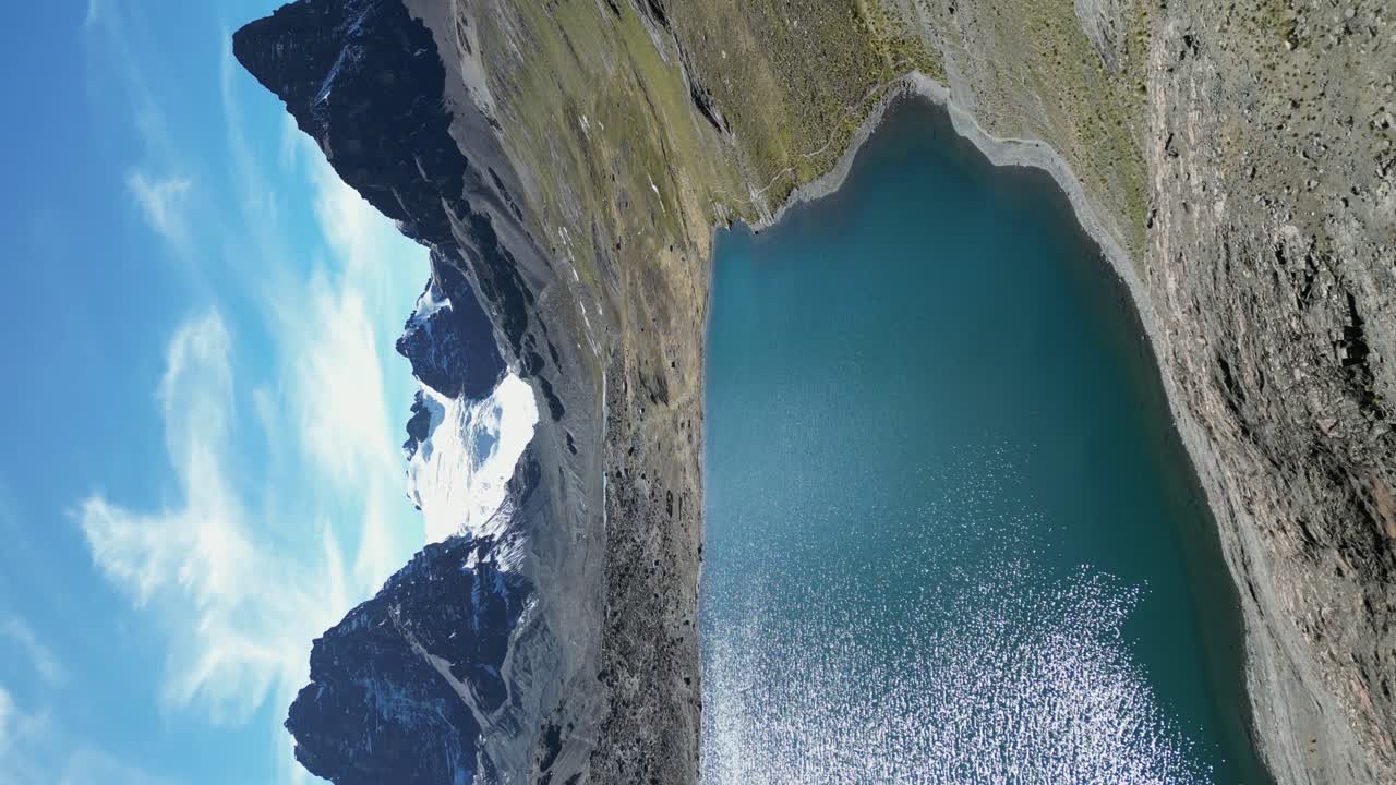 관광 경로는 눈 인 볼리비아 안데스 산맥의 크레이터 호수 가장자리를 따라갑니다.