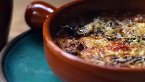 berenjenas, feta y tomate horneado en un plato de barro, zoom