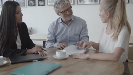 adult daughter and mature father signing agreement with female advisor