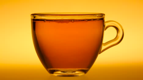 tea being poured into a glass cup against a warm background