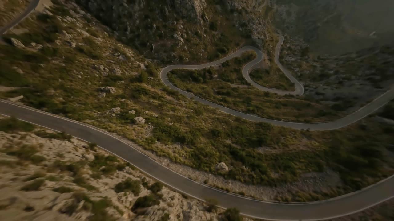 fpv drone disparó volando sobre la carretera de la serpiente a lo largo de la ladera de la cordillera rocosa en sa calobra, mallorca, españa durante el día