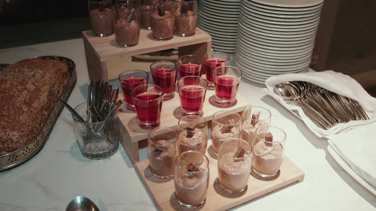 bicchierini da dessert con mousse al cioccolato e gelatina rossa su espositore in legno
