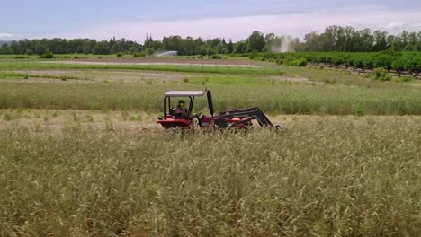 farmer mowing farmland with modern agricultural machine