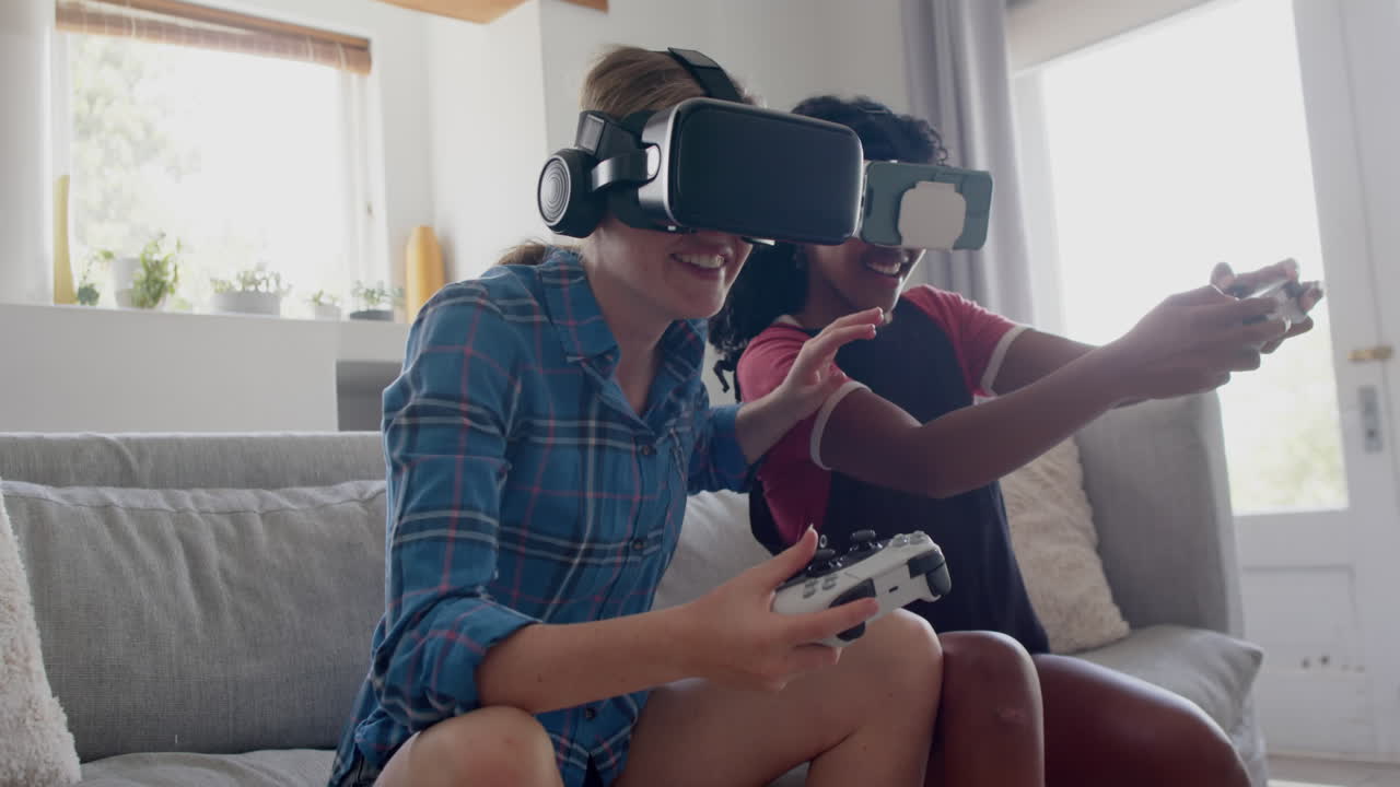 amigas adolescentes felices y diversas jugando videojuegos con auriculares vr en casa, en cámara lenta