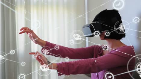 Animation-of-network-of-connections-with-icons-over-woman-wearing-vr-headset