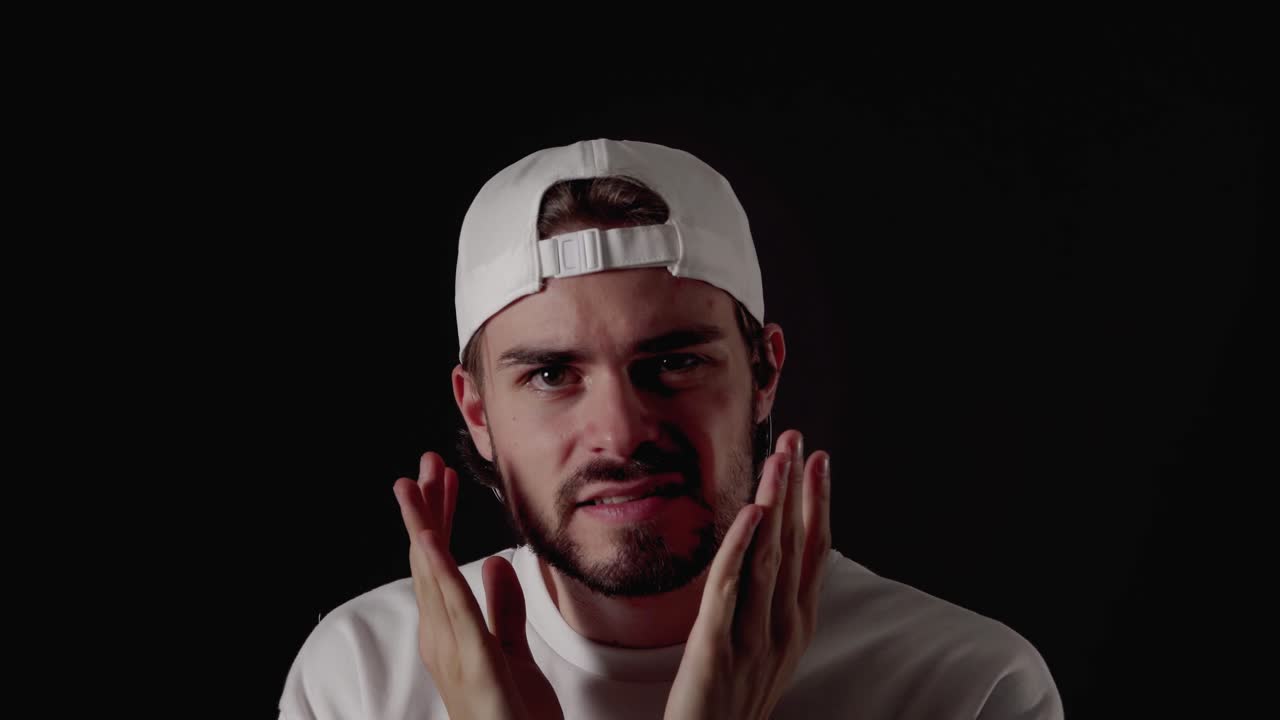 트렌디한 20대 남성이 흔들리고 놀란 몸짓, 가까운 검정색 배경