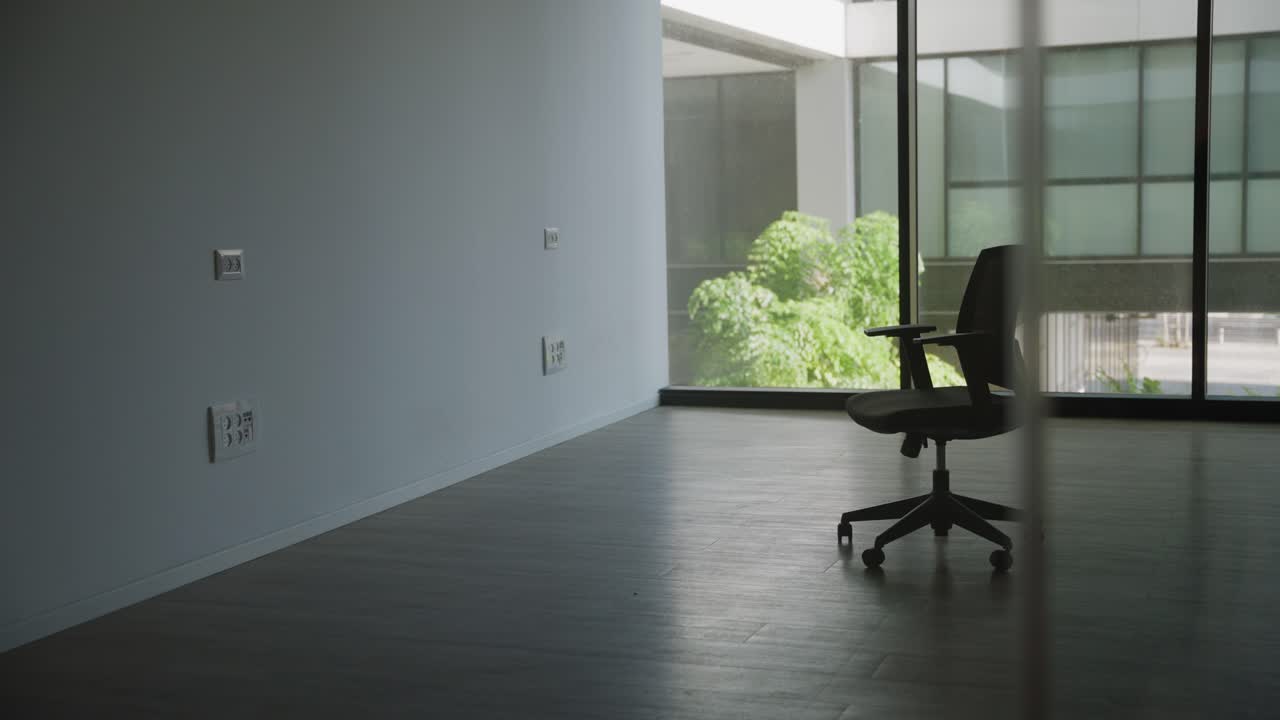 Empty modern office room with one chair and glass windows before moving in or business going bankrupt or out of business. No people in abandoned office building or open space. New start up fresh start