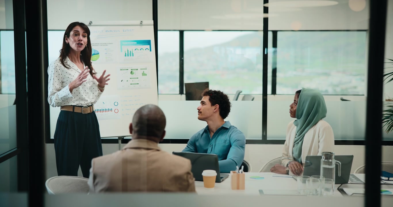 Businesswoman Presenting Data to Diverse Team in Modern Office