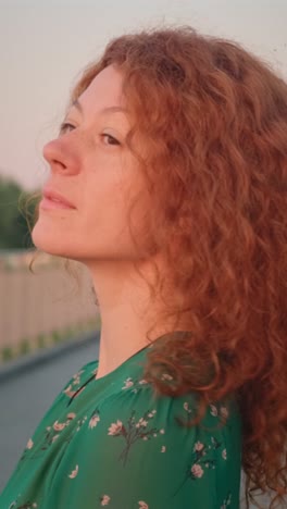 woman with red curly hair and green dress