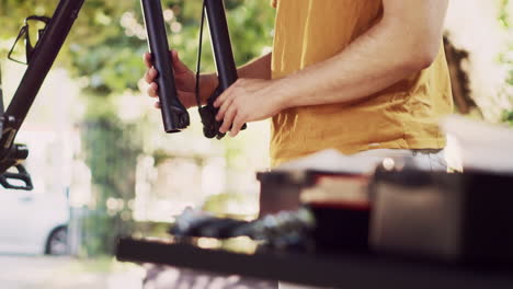 person repairing bicycle front fork