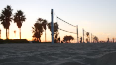 players playing volleyball on beach court, volley ball game with ball and net.