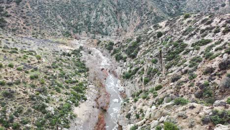 Fast-aerial-tilt-reveal-of-the-desert-landscape-in-Deep-Creek,-Hesperia-in-California,-USA