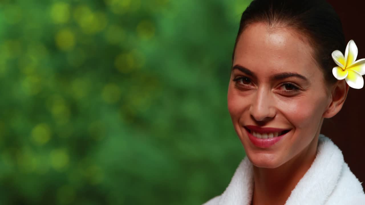 Morena contenta en bata de baño sonriendo a la cámara