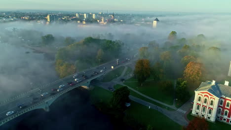 aerial drone shot of thick fog covering the city of jelgava, latvia during morning time