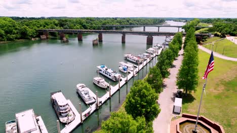 augusta georgia aerial view of savannah river as drone passes american flag, boats docked at port