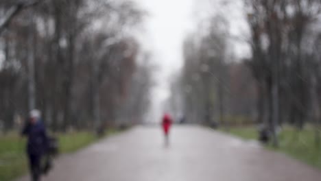 personas borrosas caminando rápidamente bajo la nieve que cae en la ciudad de invierno