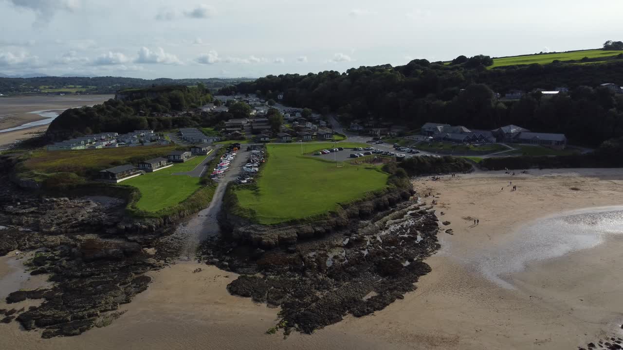 vista aérea que desciende a la taberna costera de la bahía del muelle rojo en la isla de anglesey, norte de gales