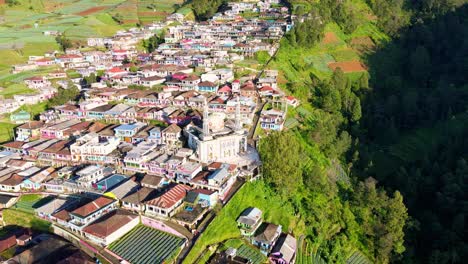 aerial view of indonesian countryside on the slope of mountain with a mosque built on it