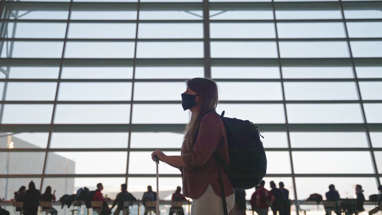 Woman in a mask waiting for her flight