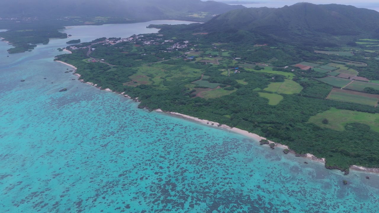 Riprese aeree orizzontali con movimento laterale a sinistra lungo la baia di Kabira, l'isola di Majipanari e l'isola di Kojima, isola di Ishigaki, Okinawa, Giappone