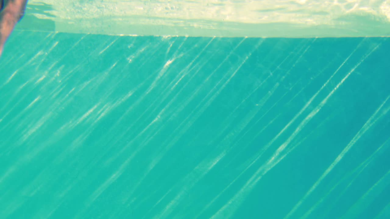 una rubia sexy en bikini azul saltando a la piscina