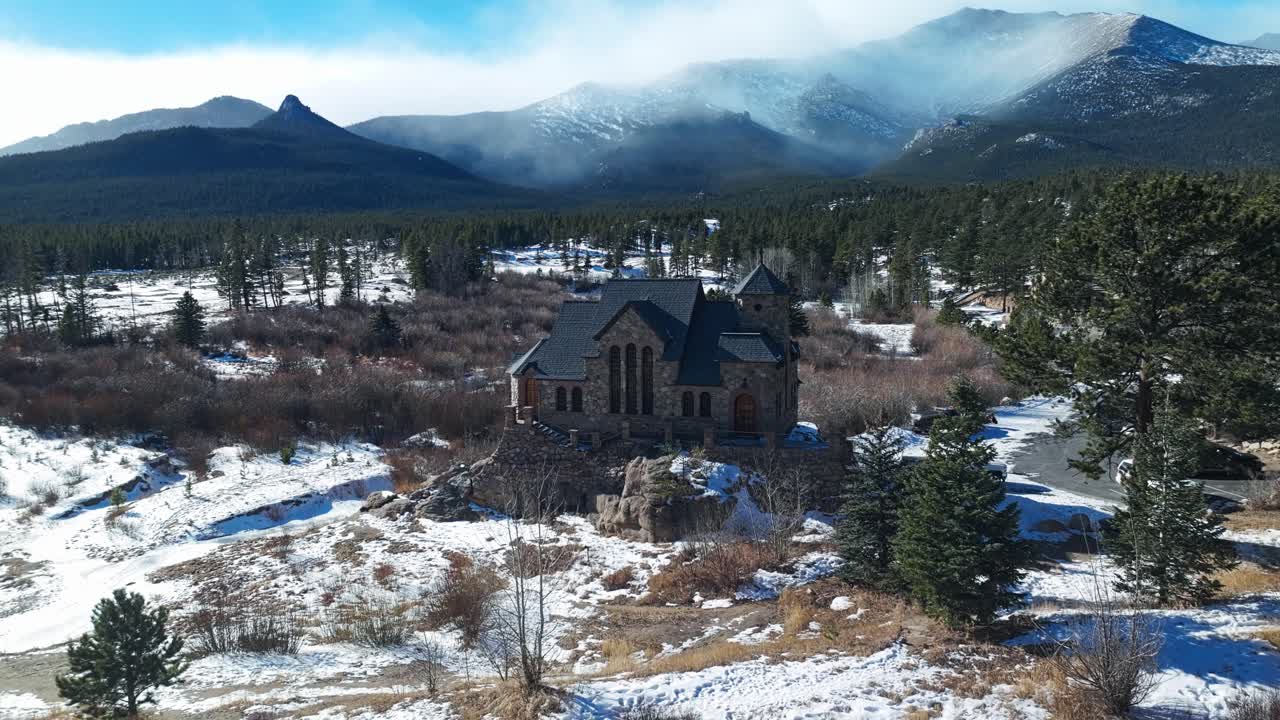 retiro aéreo a través de la capilla en la roca con una ligera cubierta de nieve en el suelo