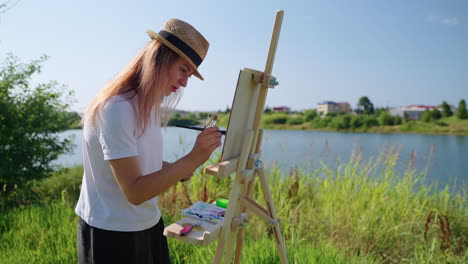 woman painting outdoors by a lake