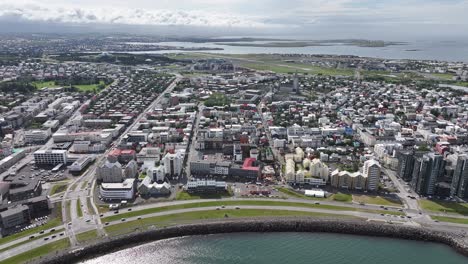 aerial view of reykjavik city center, iceland, coastal traffic, downtown buildings and church, drone shot 60fps