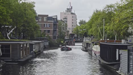 barco que se mueve sobre el canal en el centro de la ciudad de ámsterdam