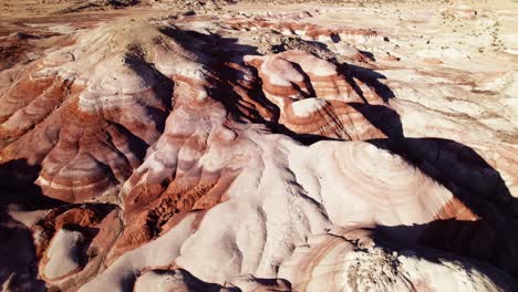 aerial 4k drone reverse flyover view of bentonite hills, utah, at golden hour with colorful mars like landscape