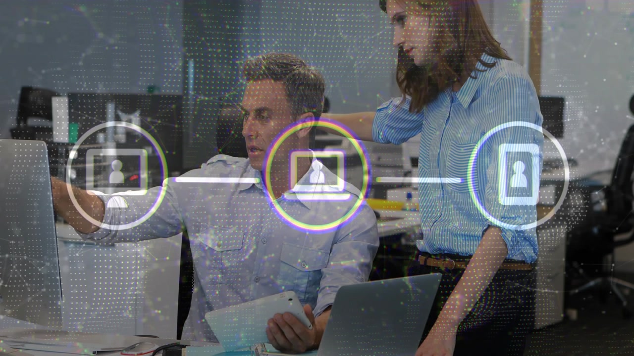 Two coworkers pointing at tablet, reacting to network icons highlighting nodes, reviewing data