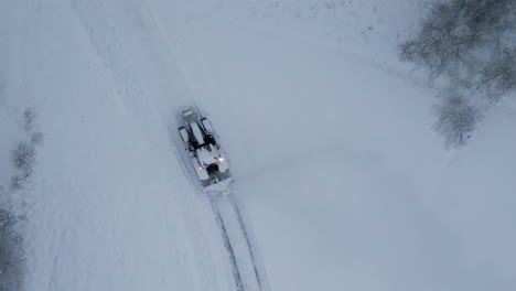 aerial top down view of tractor plowing snow in a artic environment