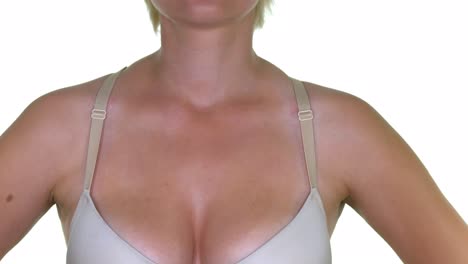 attractive young woman with large natural,breasts corrects bra straps. close up of the heavy big breasts of a woman in a big bra