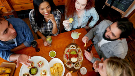 Friends-having-dinner-and-drinks-in-bar-4k