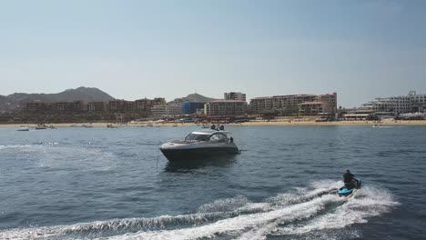 Luftdrohnenaufnahme-Des-Hafens-Und-Des-Strandes-Von-Cabo-San-Lucas-Mit-Luxusjachtbooten-Und-Einem-Kreisenden-Jetski