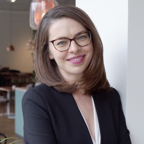 portrait of young smiling businesswoman standing in modern office interior