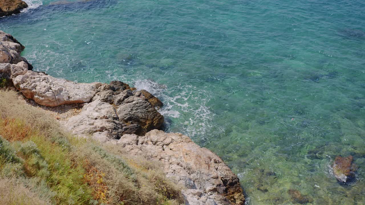 волны бьются о скалистое побережье средиземного моря, кушадасы, турция