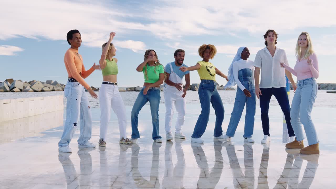 Group of young people dancing by the pier
