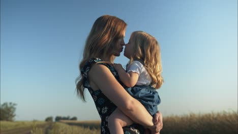mother and daughter sharing a tender moment in a wheat field