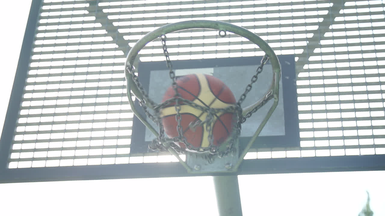 baloncesto golpeando la canasta en cámara lenta en un día soleado