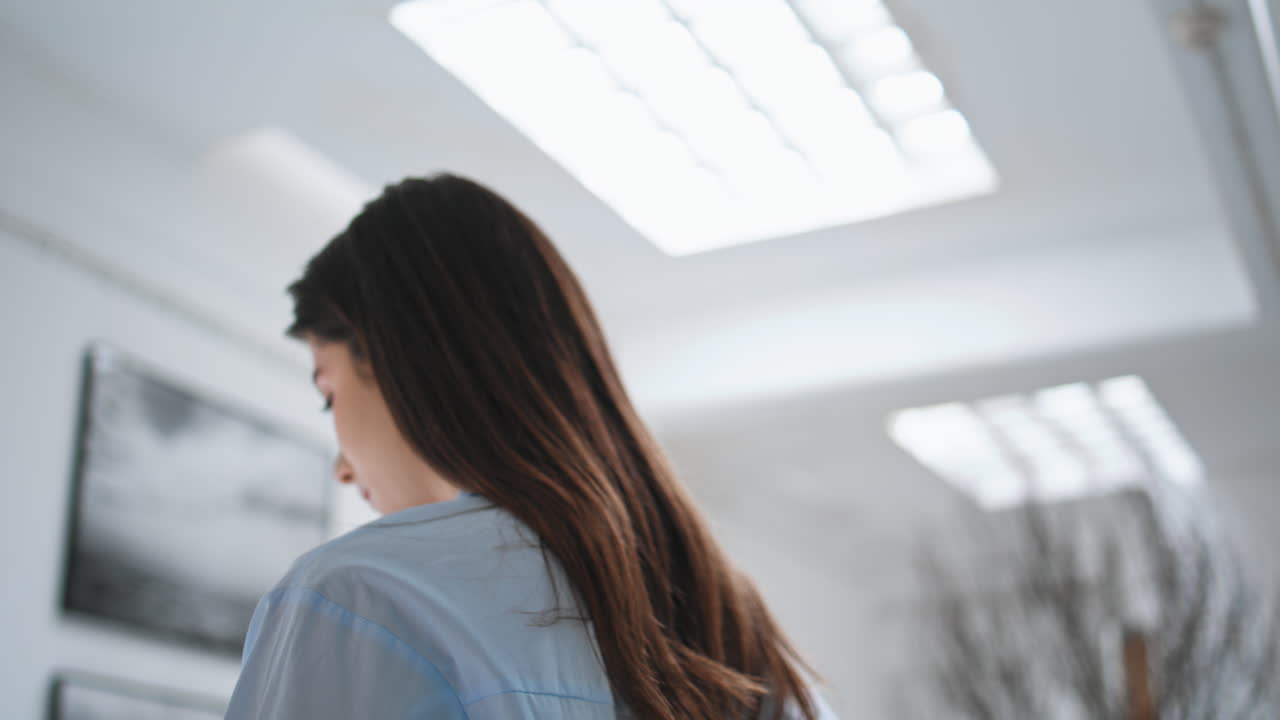 사려 깊은 소녀가 갤러리를 방문합니다. 현대 미술을 즐기는 아름다운 여성