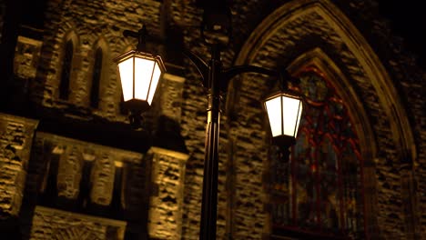 night time exterior shot of a exterior chandelier style light pole in front of the beautiful and historic christ church cathedral at sparks street in ottawa, ontario, canada