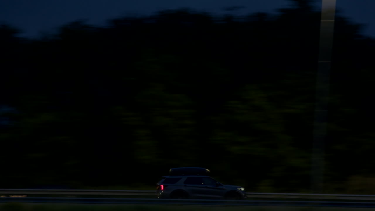 suv가 밤에 고속도로를 운전하고 있습니다.