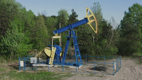 industrial oil pumpjack at work pumping crude oil with drilling rig in oilfield near campina in romania