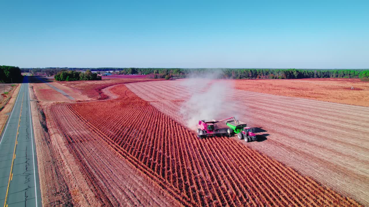 la soja combina la cosechadora roja con el tractor para descargar la soja mientras se conduce