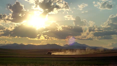 Cosechadora-En-La-Zona-Rural-De-Colorado,-En-Un-Contexto-De-Montañas-Y-Puesta-De-Sol