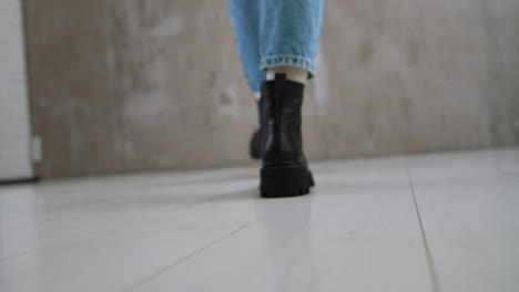 woman walking in black boots and blue jeans
